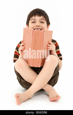 Casual happy seven year old french american boy with large book over white background. Stock Photo