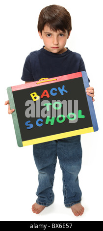 adorable unhappy seven year old boy holding blank chalk board that reads back to school Stock Photo