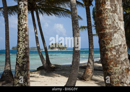 Islands in the San Blas archipelago in the Caribbean Sea, seen through palm trees on Dog Island, Panama, Central America Stock Photo