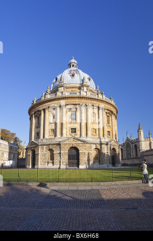 Student stands in front of Radcliffe Camera, Oxford University, Oxford, Oxfordshire, England, United Kingdom, Europe Stock Photo