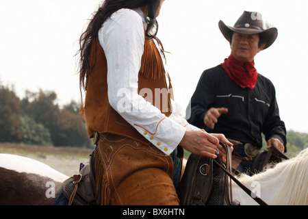Two horseback riders talk. Anping, Tainan, Taiwan Stock Photo
