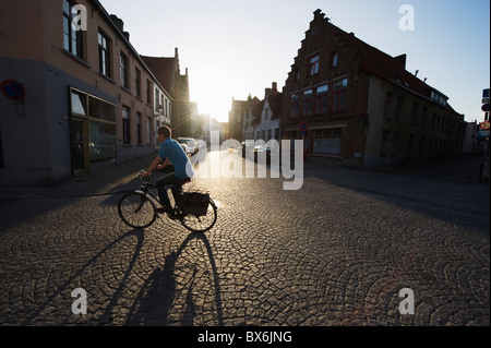 Sunset and shadow of a cyclist on cobbled street, old town, UNESCO World Heritage Site, Bruges, Flanders, Belgium, Europe