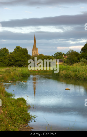 Burford Church spire reflected in the River Windrush watermeadows in the Cotswolds, Burford, Oxfordshire, England. Stock Photo