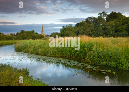 Burford Church spire reflected in the River Windrush watermeadows, Burford, The Cotswolds, Oxfordshire, England. Stock Photo