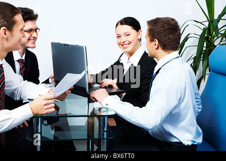 Photo of co-workers looking at each other with smiles while working Stock Photo