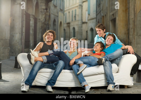 Group relax on couch laughing in street Stock Photo