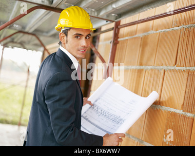 architect with blueprint in construction site Stock Photo