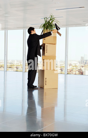 Business man packing cardboard boxes in empty office space Stock Photo