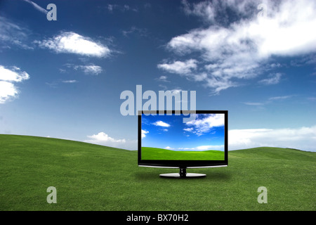 Modern television on a green meadow, showing the colors more beautiful than reality Stock Photo
