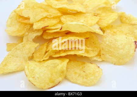 Pile of potato crisps on a plain white background Stock Photo