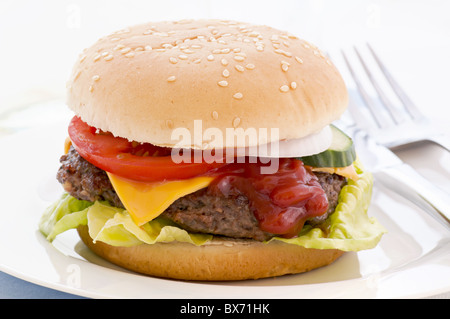 American cheeseburger stuffed with beef patty und cheddar as closeup on white background Stock Photo