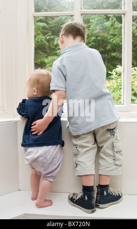 Brother supporting baby sister Stock Photo