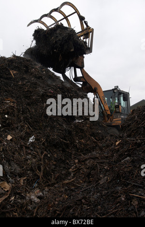 Front loader on compost heap at recycling centre Stock Photo