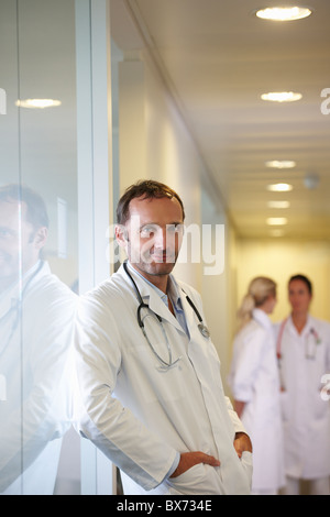Doctor against a window, smiling Stock Photo