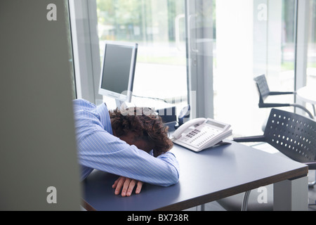 Man sleeping on his office desk Stock Photo
