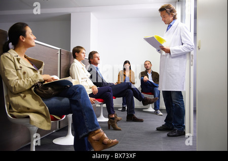 Doctor calling a patient in waiting room Stock Photo