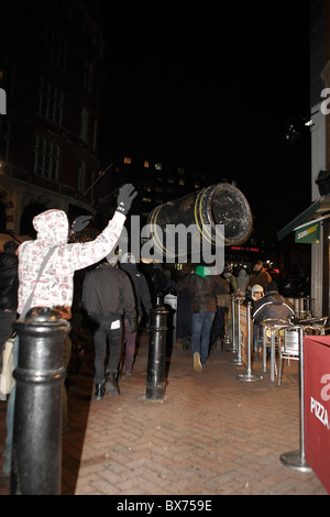 Protester throws a rubbish bin at diners in Westminster during student demo Stock Photo