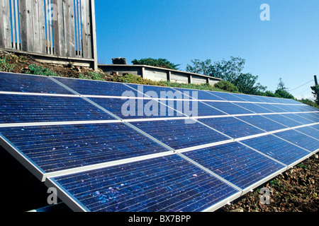 Solar Electric Panels installed on slope below family home, Stock Photo