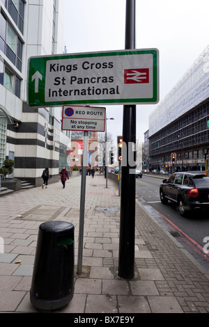 Sign for Kings Cross & St Pancras International railway stations & a red route, no stopping sign, London, UK Stock Photo