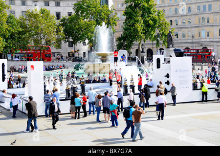 Tourists and visitors in Trafalgar Square with chess tournament using oversized pieces part of the London Design Festival event sunny day England UK Stock Photo