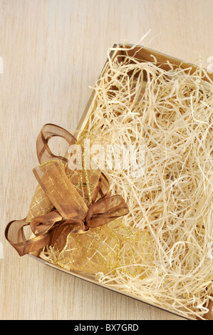 Open gift box and bow - filled with packing bast - detail Stock Photo