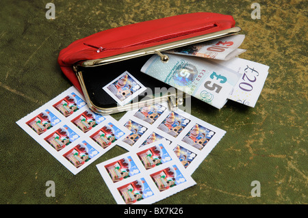 Cash in a red leather purse with Christmas theme British postage stamps Stock Photo