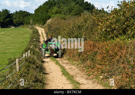 dh Herm Island HERM GUERNSEY herm farmer driving tractor along country lane farming channel islands Stock Photo