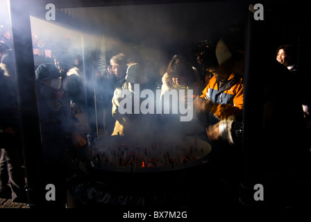 believers burning incense at a buddhist temple in tokyo during new year's shogatsu celebrations, japan Stock Photo