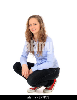 Attractive young girl in squatting position. All on white background. Stock Photo