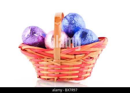 easter basket filled with chocolate eggs isolated over white Stock Photo