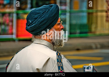 Portrait of Indian man walking across street in Singapore Little India Stock Photo