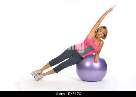 50yr old demonstrating side plank on fit ball Stock Photo