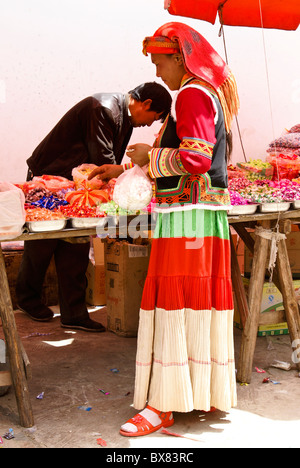 Yi woman buying sweets in market, Shaxi, Jiangsu, China Stock Photo