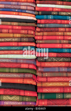 Colourful silk textiles on display at a market stall in Luang Prabang, Laos