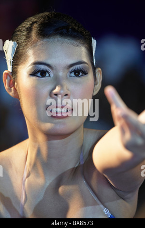 Close up of female dancer performing on stage with arm gesture and reaching out. Thailand S. E. Asia. Stock Photo