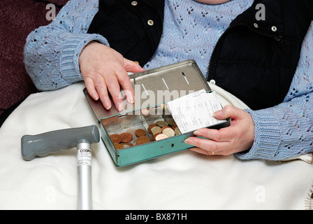 pensioner with cash tin and English currency Stock Photo