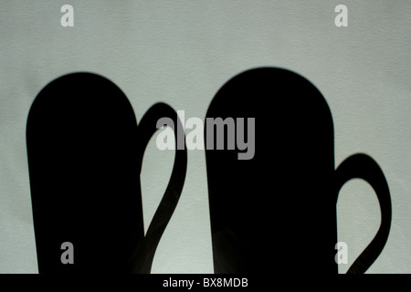 Shadows of two cups in a grey background Stock Photo