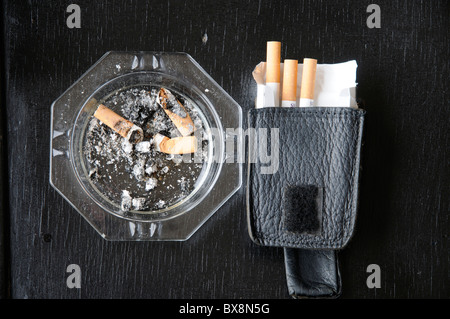 DIRTY ASHTRAY CONTAINING CIGARETTE BUTTS Stock Photo