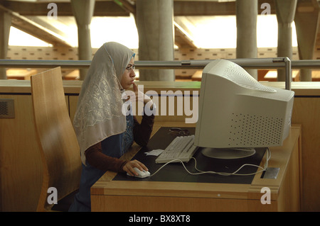 An Egyptian student wearing a Hijab using a computer at the Bibliotheca Alexandrina a major library and cultural center in the city of Alexandria northern Egypt Stock Photo