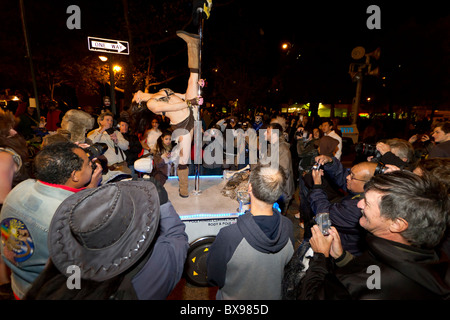 A female pole dancer on a float performs for a crowd of mostly males in the 2010 Greenwich Village Halloween parade in New York Stock Photo