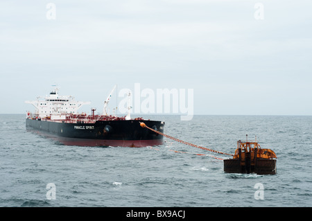 Oil tanker ship anchored in offshore area waiting to be loaded by a production oil rig from petrobras, brazilian oil company. Stock Photo