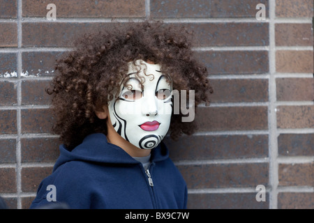 A curly haired young man in an eerie mask at the 2010 Greenwich Village Halloween parade in New York City Stock Photo