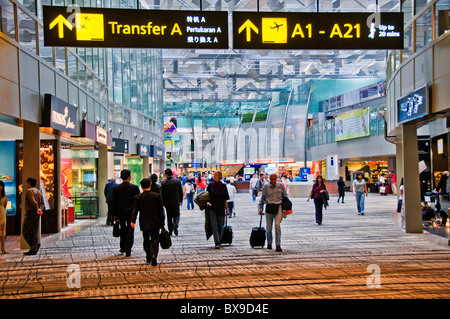 people walking in glass atrium lobby Interior of new modern Changi airport terminal in Singapore southeast Asia Stock Photo