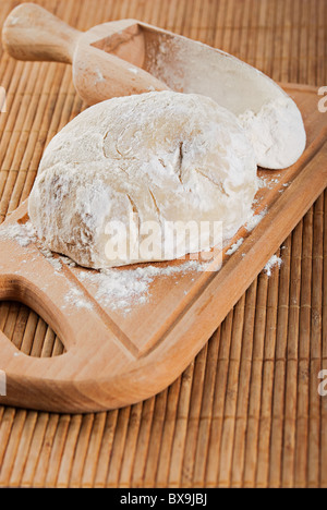 Flour in spoon and fresh doug for making bread Stock Photo
