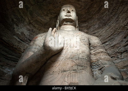 Giant Buddha statue carved inside the ancient Yungang Grottoes, Datong, Shanxi, China. Stock Photo