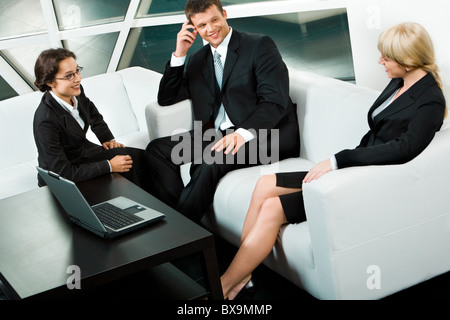 Portrait of smiling business people sitting on the sofa and discussing new project Stock Photo