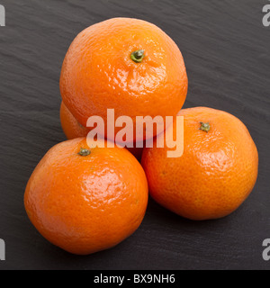 Clementine's from low perspective isolated on dark grey slate background. Stock Photo