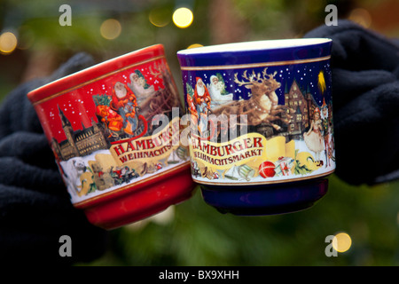2 mugs of hot gluhwein / mulled wine in front of a christmas tree at the Christmas Market in the Rathausplatz in Hamburg Stock Photo