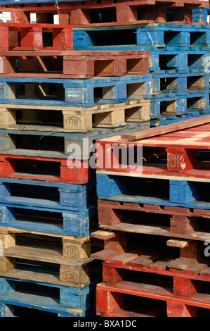 Pile or Stack of Red and Blue Coloured Wooden Pallets, Timber Pallets or Europallets Stock Photo