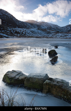 Frozen Styhead tarn in winter with Great End and Scafell Pike beyond, Lake district, Cumbria Stock Photo